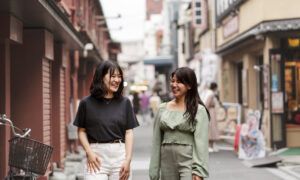 Quelles sont les tendances mode en Corée du Sud ? Deux femmes souriantes marchant dans une rue urbaine