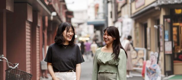 Deux femmes souriantes marchant dans une rue urbaine