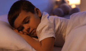 Quel type d’éclairage choisir pour la chambre d’un enfant ? Enfant dormant paisiblement dans son lit la nuit