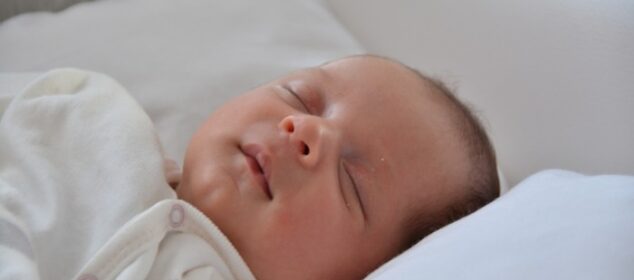 Bébé endormi sur un oreiller blanc