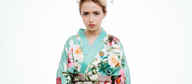 Jeune femme en kimono floral, air sérieux