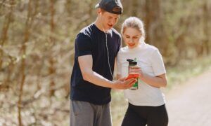 Les protéines pour sportifs : comment choisir la meilleure option pour votre entraînement ? Jeune couple regardant un smartphone en forêt