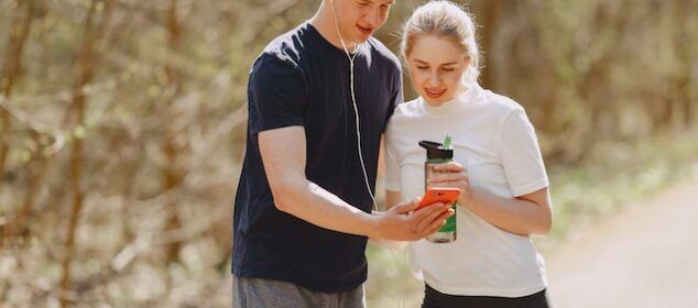 Jeune couple regardant un smartphone en forêt