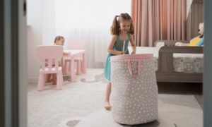 Quels types de rideaux pour la chambre d’une petite fille ? Fillette portant un grand panier à linge