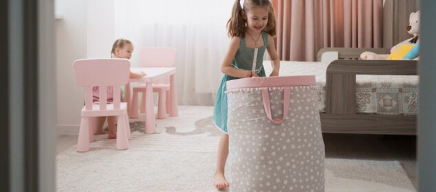 Fillette portant un grand panier à linge