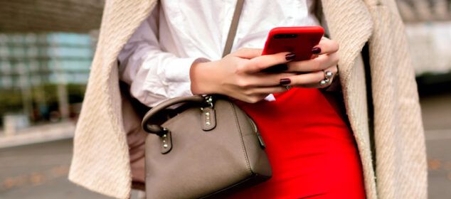 Femme tenant smartphone rouge en ville
