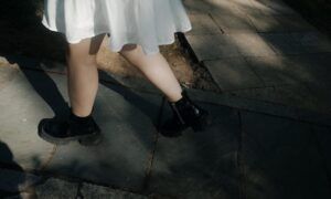 Un pas vers l’originalité : l’engouement pour les mocassins à plateforme chez les femmes Personne en robe blanche et bottines noires