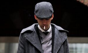 La casquette plate : indémodable ! Homme en manteau gris fumant une cigarette