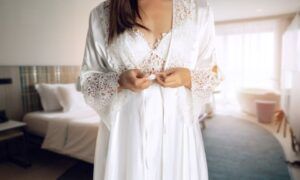 Élégance nocturne : Comment porter une nuisette longue avec style ? Femme en peignoir blanc dans chambre lumineuse