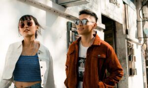 Guide d'achat : Comment choisir le blouson parfait pour l'hiver ? Deux jeunes adultes marchant en ville ensoleillée