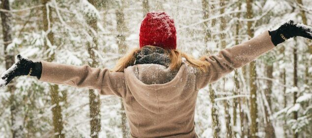 Personne bras ouverts sous la neige en forêt