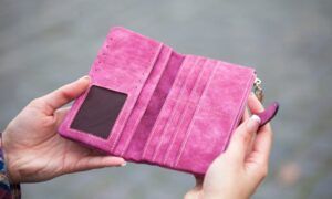 Portefeuilles pour femmes : Allier mode et organisation au quotidien Portefeuille rose ouvert tenu entre deux mains