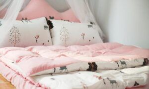 Rafraîchir efficacement sa chambre à coucher : nos astuces Lit enfant rose avec coussins motifs animaux