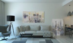Comment utiliser des foulards et des écharpes pour créer des accents de couleur dans votre intérieur ? Salon moderne avec canapé blanc et tableau abstrait