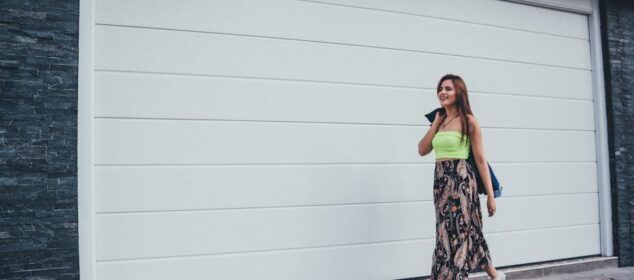 Femme marchant devant un garage moderne blanc