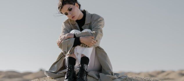 Femme assise sur dune, paysage désertique