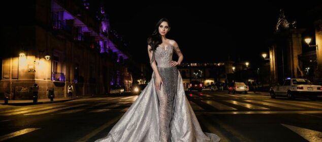 Femme en robe argentée au milieu d’une rue nocturne