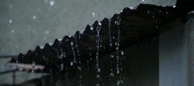 Pluie ruisselant d’un toit en tôle sombre