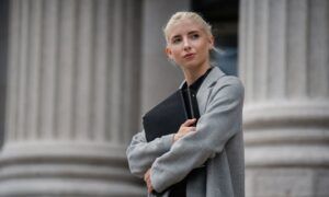 Blazer et couleurs : Trouvez la palette idéale pour votre teint et votre style Femme blonde tenant un dossier devant colonnes