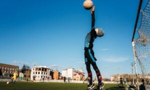 Gants de gardien pour enfants : les caractéristiques à prendre en compte Jeune gardien sautant pour attraper le ballon