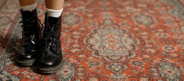Bottes noires sur tapis oriental rouge