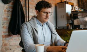 Cardigan épais pour homme : le vêtement idéal pour l'hiver rigoureux Homme travaillant sur ordinateur portable dans un café