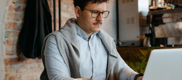 Homme travaillant sur ordinateur portable dans un café