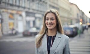 Comment adapter vos coiffures à votre look ? Femme souriante en blazer gris en ville