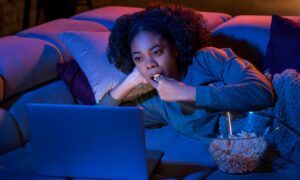 Plateformes de streaming : une solution pratique pour regarder vos programmes préférés chez soi Femme regardant un ordinateur portable en mangeant du popcorn